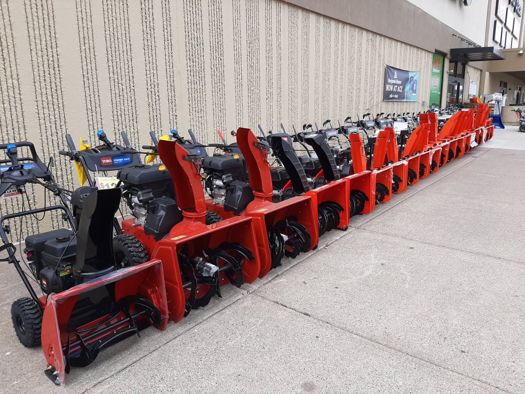 a long row of snowblowers outside the hardware store